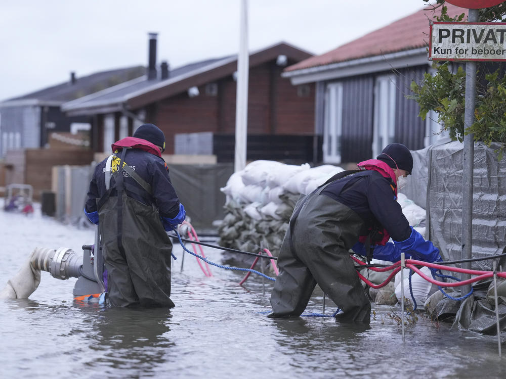 People try to pump water away in a flooded neighborhood in Haderslev, Denmark, on Friday.