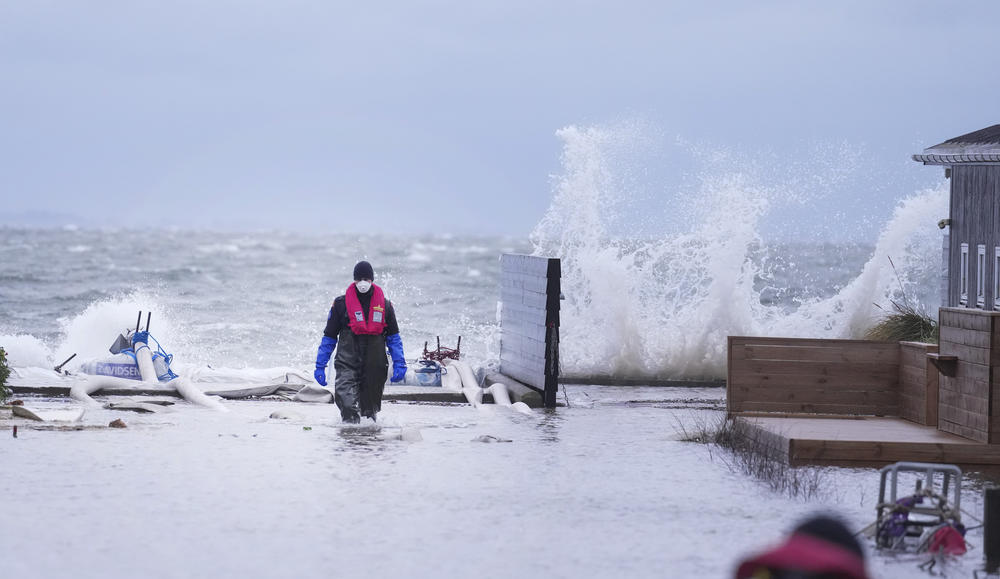 A man walks in a flooded neighborhood in Haderslev, Denmark, on Friday.