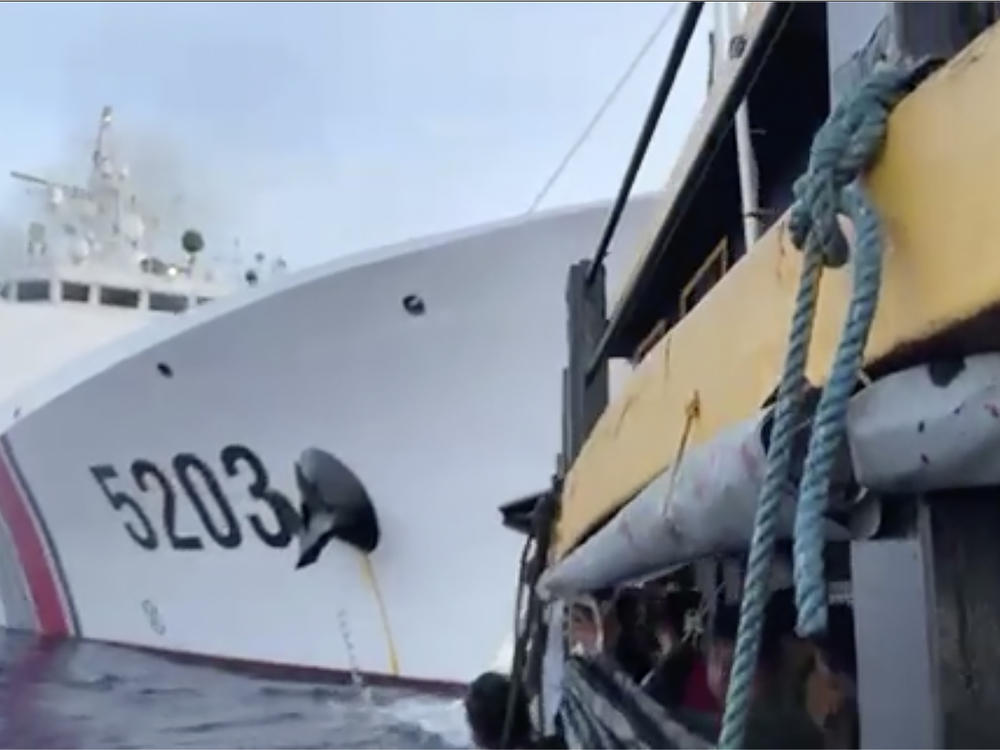 In this image from a video released by the Armed Forces of the Philippines, Filipino sailors, bottom, look after a Chinese coast guard ship with bow number 5203 bumps their supply boat as they approach Second Thomas Shoal, locally called Ayungin Shoal, at the disputed South China Sea on Sunday Oct. 22, 2023.