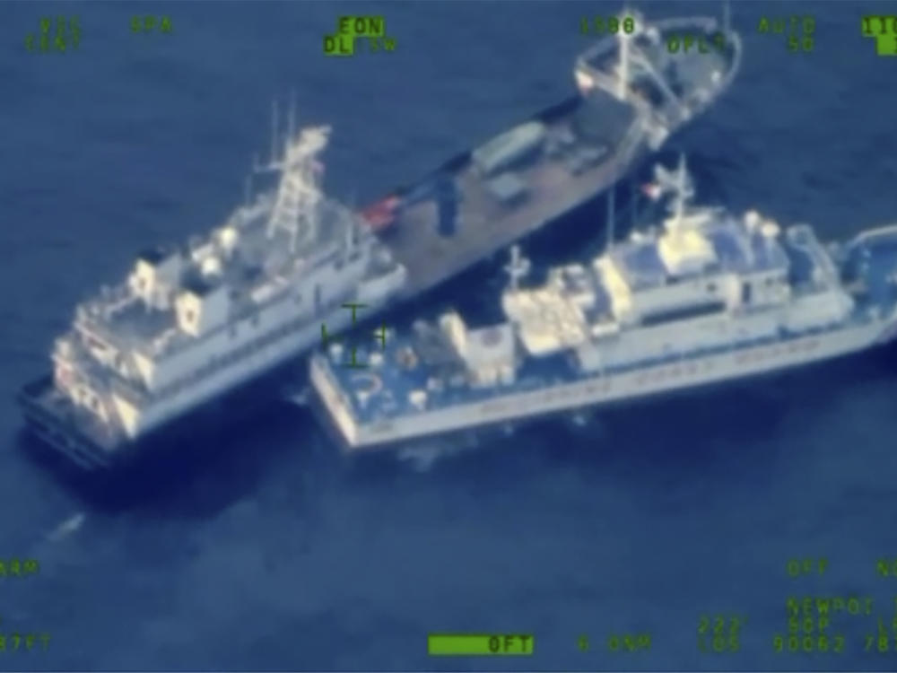 This image released by the Armed Forces of the Philippines, shows a Chinese militia vessel, top, and Philippine coast guard vessel BRP Cabra as they approach Second Thomas Shoal, locally called Ayungin Shoal, at the disputed South China Sea on Sunday Oct. 22, 2023.