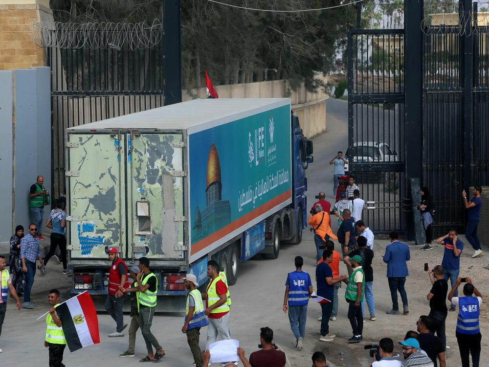 People on the Egyptian side of the Rafah border crossing watch as a convoy of lorries carrying humanitarian aid crosses to the Gaza Strip on Sunday.