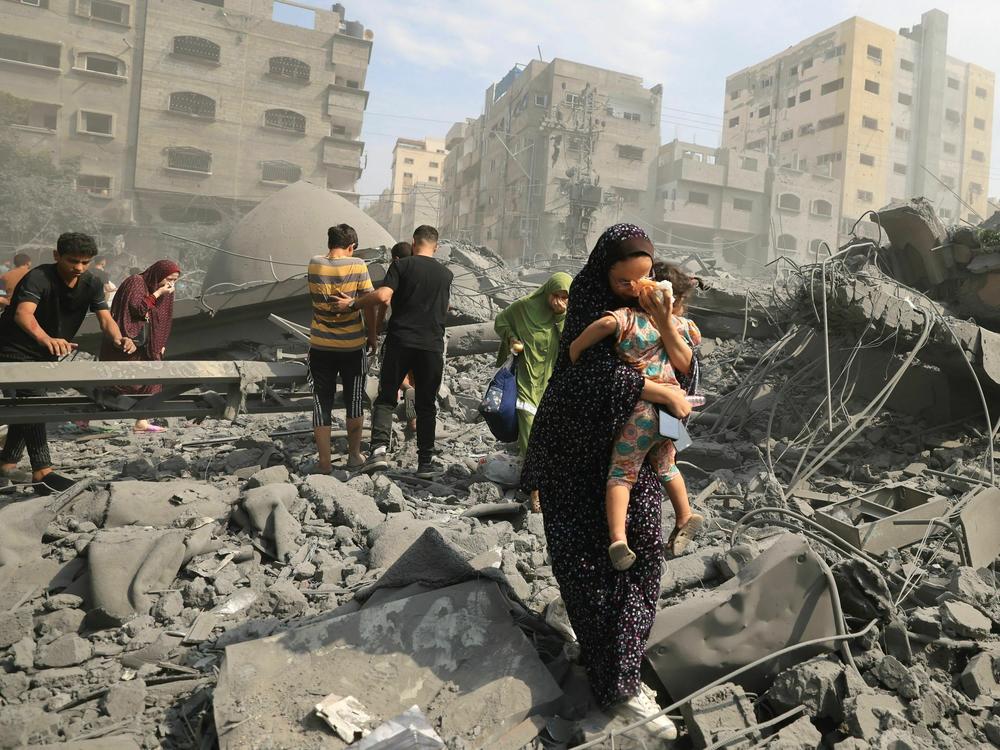 Palestinians evacuate the area following an Israeli airstrike on the Sousi mosque in Gaza City on October 9, 2023.