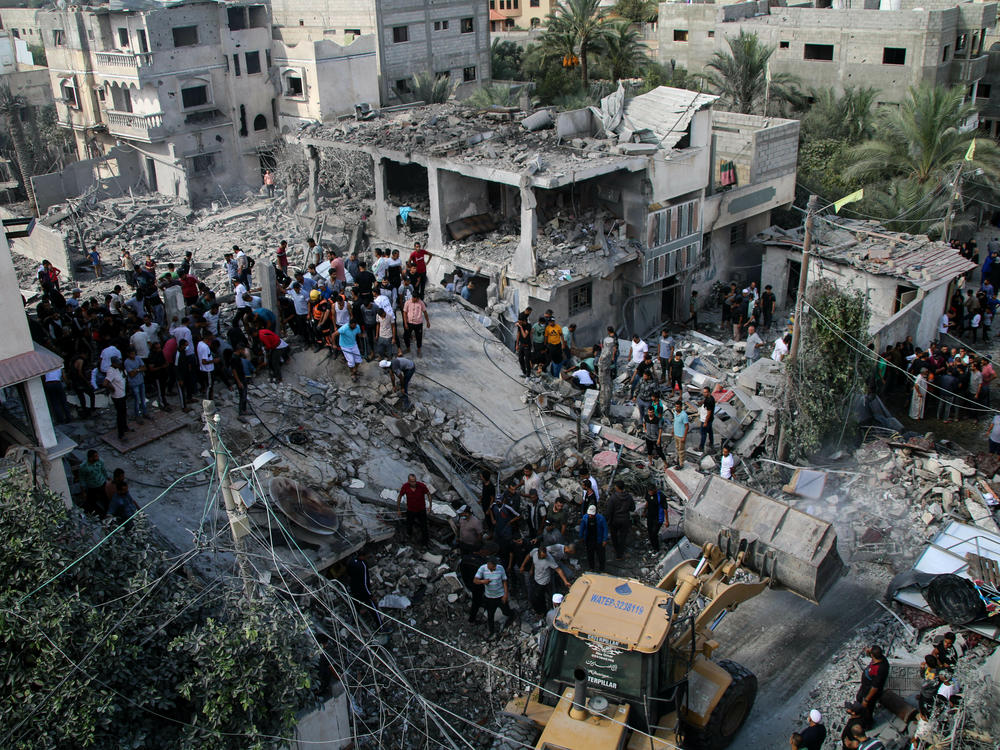 Palestinian emergency services and local citizens search for victims in buildings destroyed during Israeli air raids in the southern Gaza Strip on October 18, 2023 in Khan Yunis, Gaza.