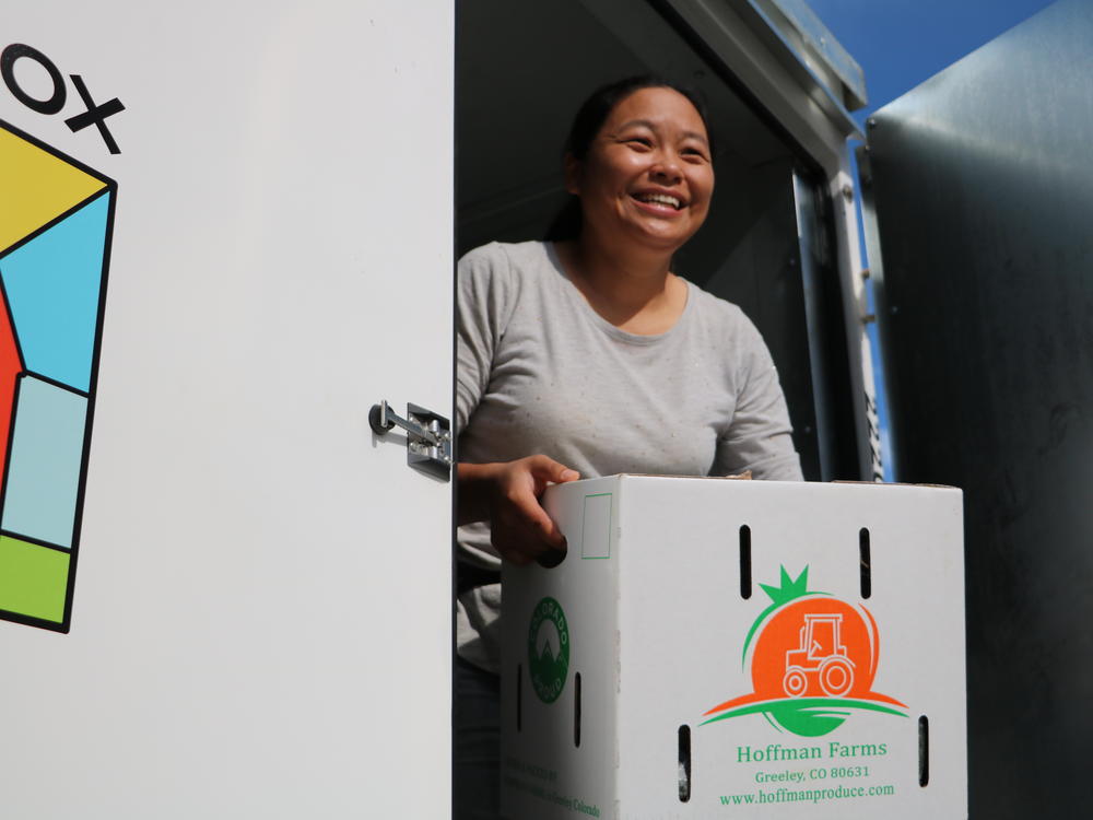 Hanmei Hoffman and her husband Derrick Hoffman farm in Greeley, Colorado, where most of their produce is sold to schools. Here she's moving boxes of cucumbers from a refrigerated container and loading them onto a waiting truck to deliver them to schools along Colorado's Front Range.