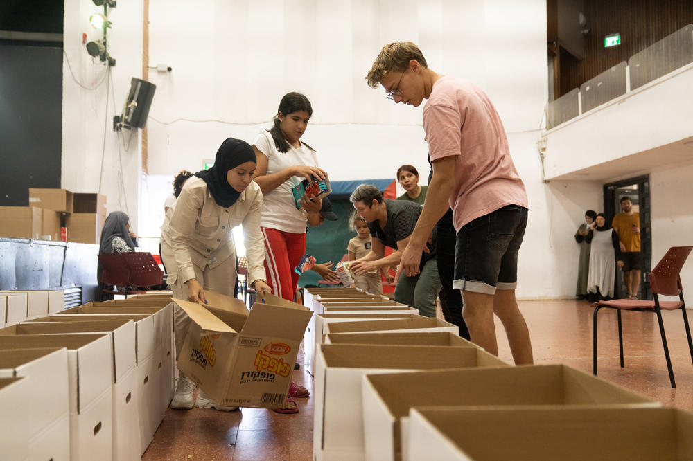 Volunteers help pack boxes of food donations at the community center in Lod.