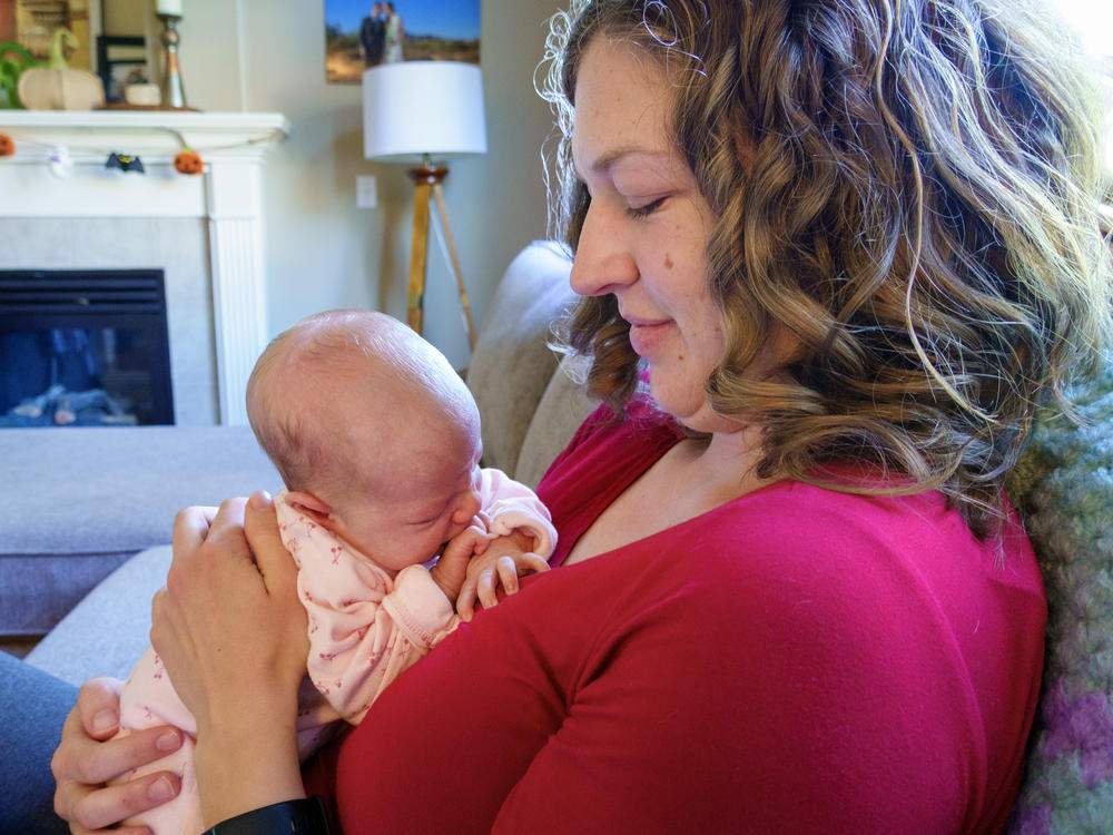 Emily Bendt cradles her two-week-old infant, Willow, at her home near Portland, OR in early October 2023. Bendt, a pediatric nurse, closely followed the recent approval of the RSV monoclonal antibody Nirsevimab but has been unable to find it for her daughter.
