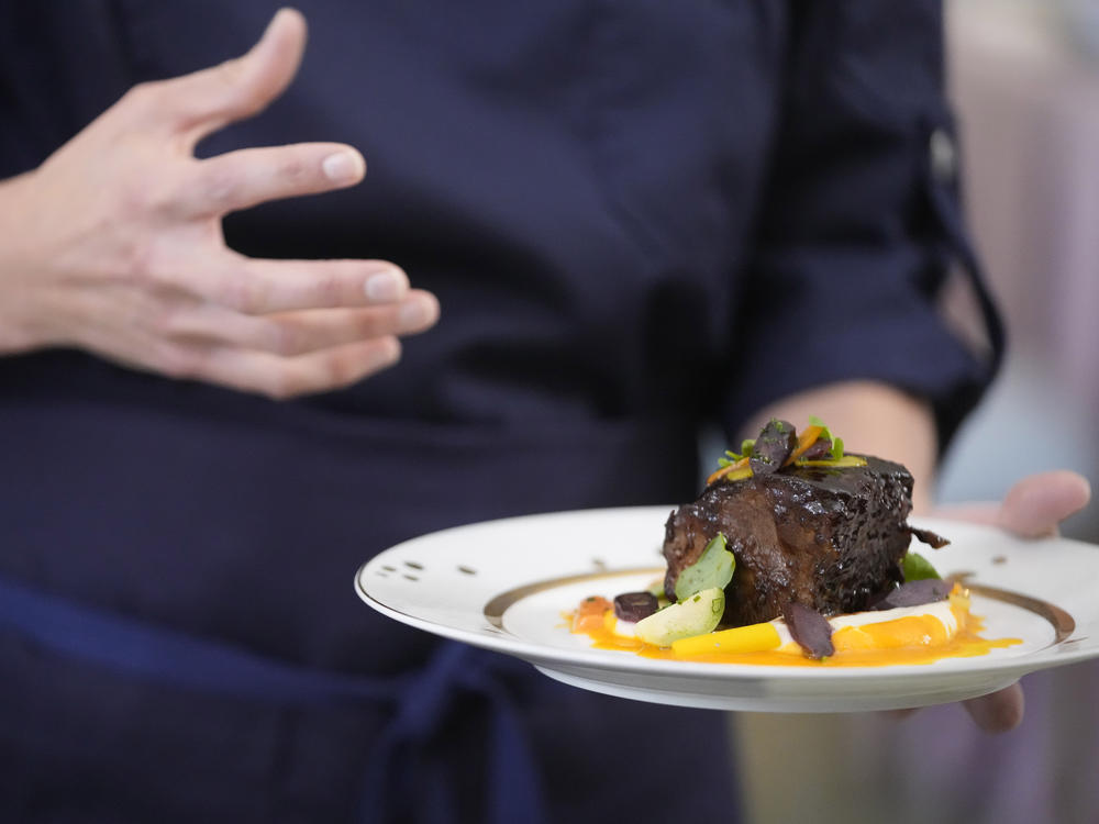 Guest chef Katie Button shows reporters sarsaparilla-braised short ribs, the main course for a state dinner for Australia's prime minister.