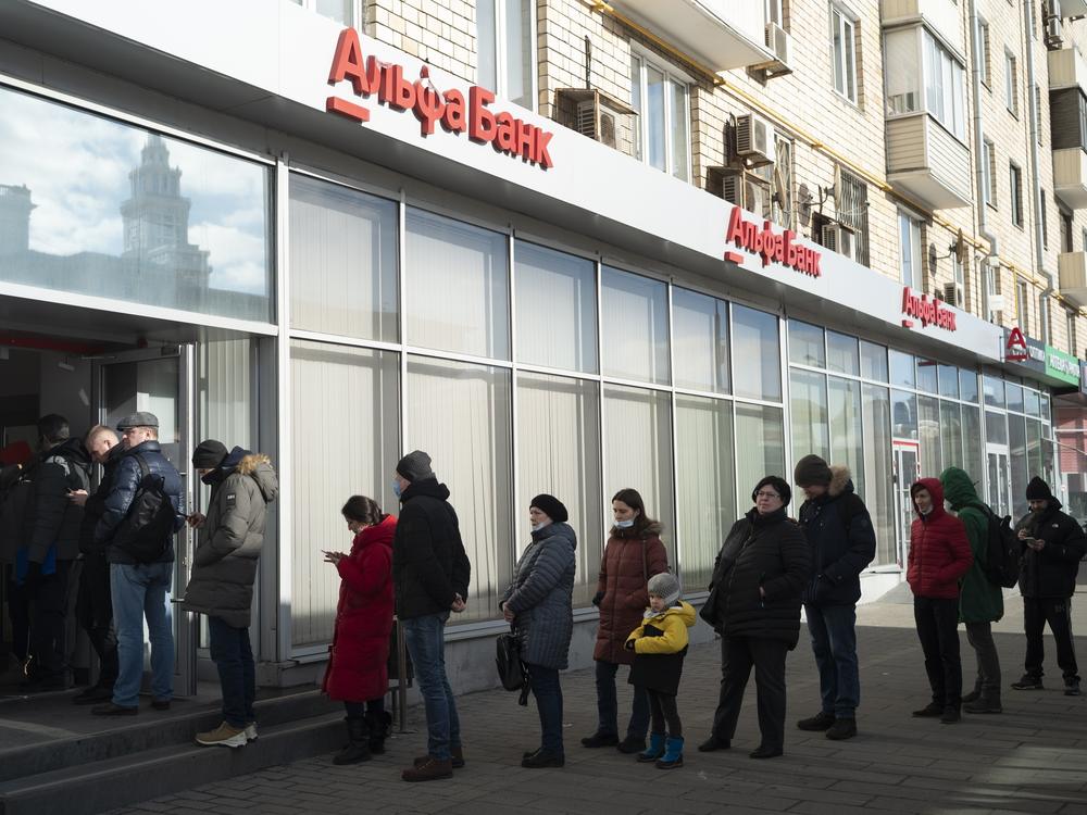 People stand in line to withdraw money from an ATM of Alfa Bank in Moscow last year.