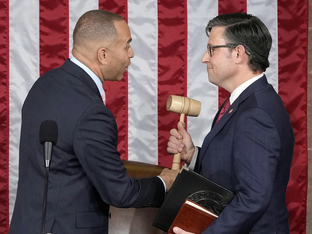 House Minority Leader Hakeem Jeffries of New York hands the gavel to newly elected House Speaker Mike Johnson of Louisiana at the Capitol on Wednesday.