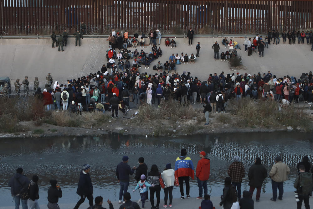 Migrants gather at a crossing into El Paso, Texas, as seen from Ciudad Juárez, Mexico, Dec. 20, 2022.