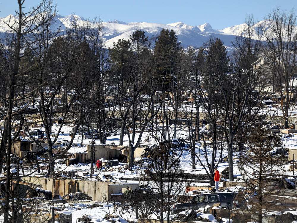 A woman looks at the remains of a home in a neighborhood decimated by a fire on January 2, 2022 in Louisville, Colorado. Nearly a thousand homes were destroyed, making it the most destructive wildfire in Colorado history.