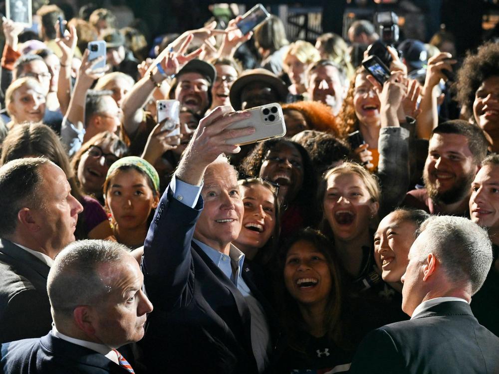 President Biden takes a selfie with supporters during a rally in New York ahead of the 2022 midterm elections.