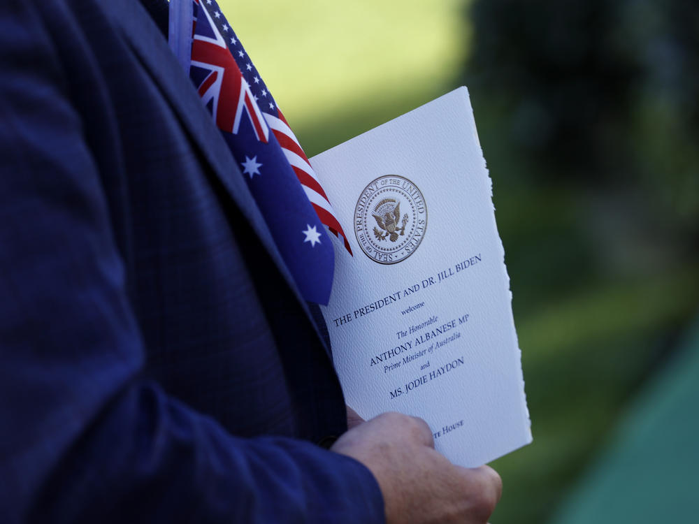 A guest on the South Lawn holds a program for the arrival ceremony for Australian Prime Minister Anthony Albanese at the White House.