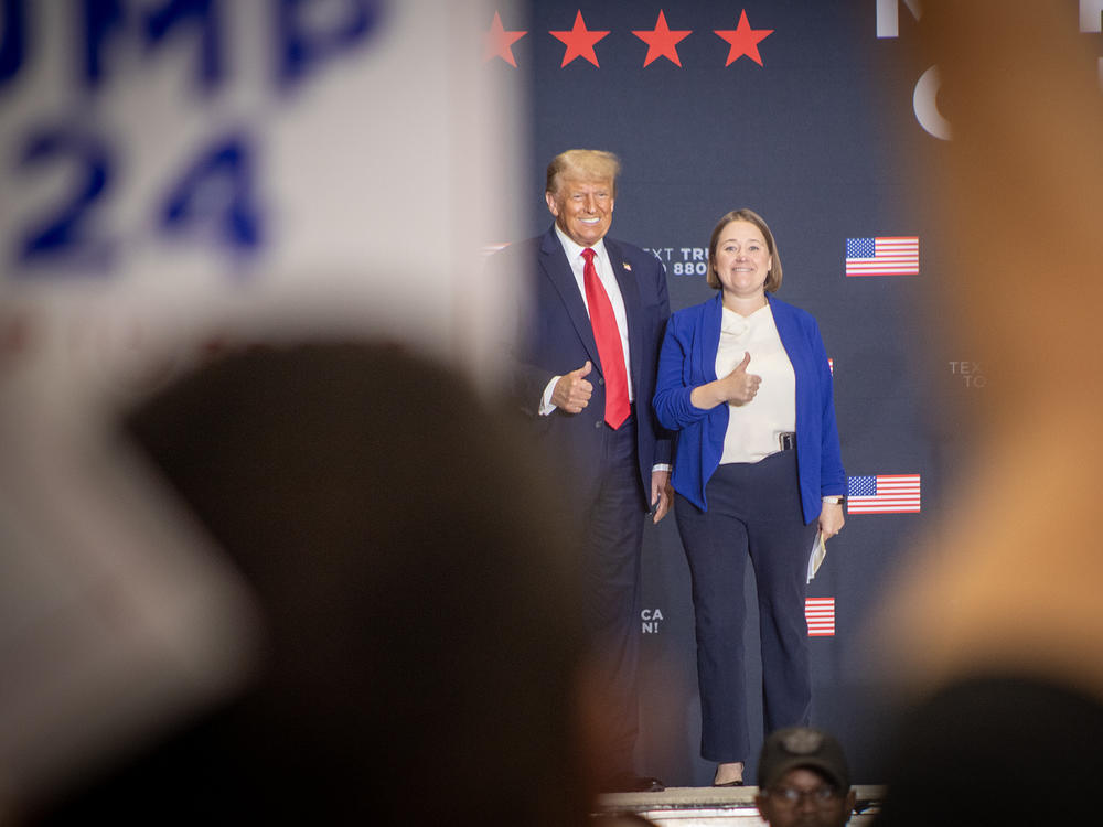 Former President Donald Trump stands on stage during a rally in suburban Des Moines with Iowa Attorney General Brenna Bird after receiving her endorsement on Oct. 16.