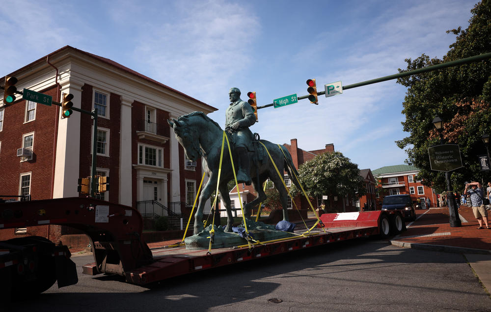A flatbed truck carries a statue of Confederate Gen. Robert E. Lee from the Market Street Park July 10, 2021 in Charlottesville, Va. Initial plans to remove the statue sparked the infamous 