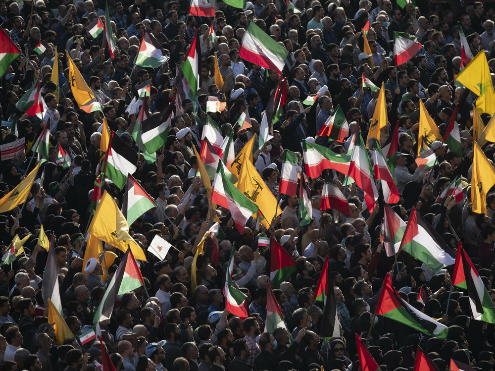 People carry Palestinian flags, Iranian flags and Hezbollah flags at Tehran's Revolution Square during an anti-Israel rally on Oct. 18.