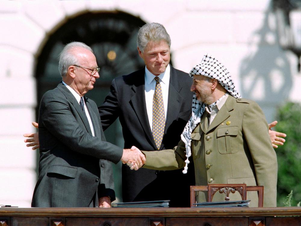 U.S. President Bill Clinton stands between PLO leader Yasser Arafat (right) and Israeli Prime Minister Yitzhak Rabin at the White House as the latter two shake hands for the first time after signing the Oslo Accords on Sept. 13, 1993.