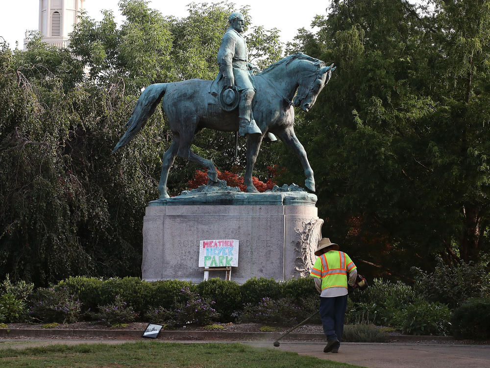 A homemade sign that says Heather Heyer Park rests at the base of the statue of Confederate Gen. Robert E. Lee in a downtown Charlottesville, Va. park on August 18, 2017. Heyer was killed by a neo-Nazi during a white nationalist rally.