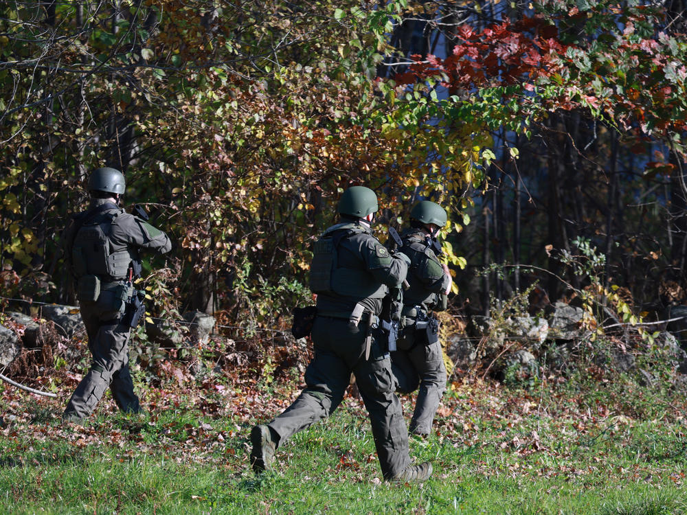 Law enforcement officials conduct a manhunt for mass shooting suspect Robert Card in Monmouth, Maine, on Friday.