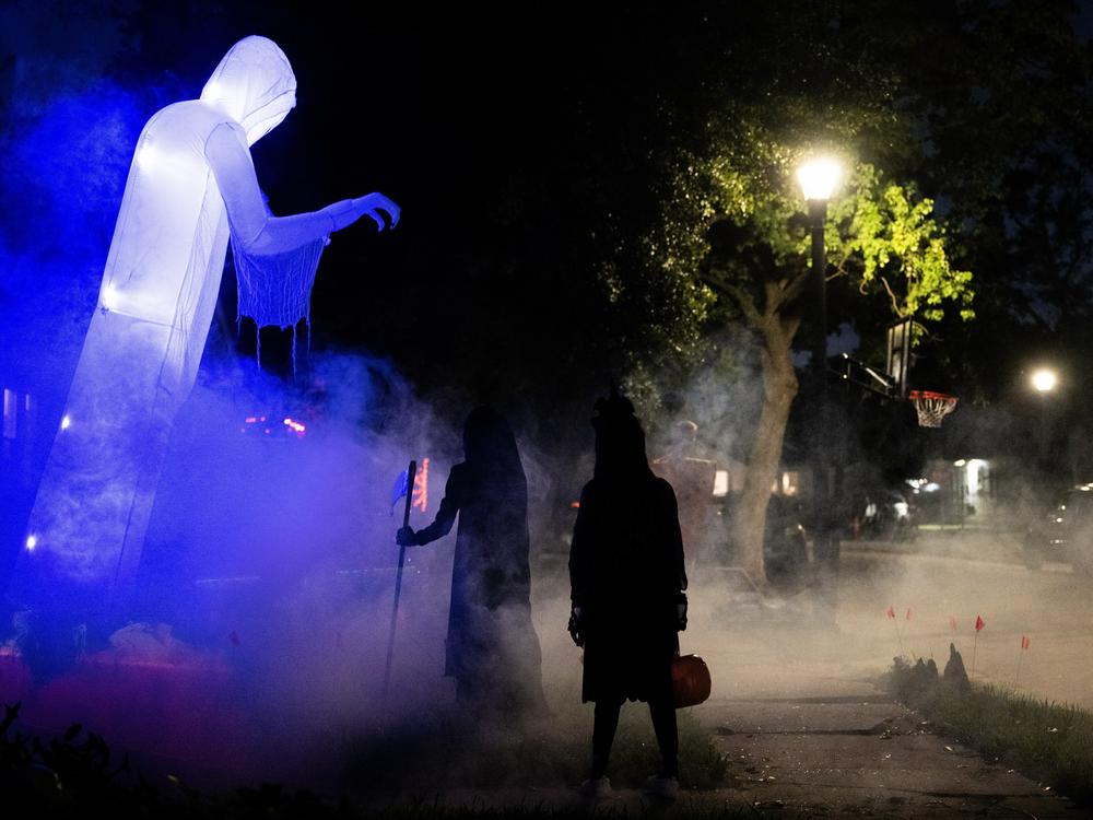Children walk past Halloween decorations last year. In several U.S. towns, it's illegal for kids over 12 years old to go trick-or-treating.