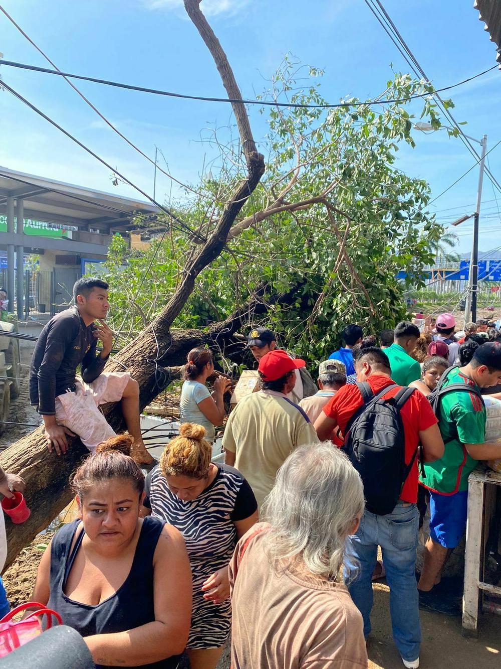 Residents in a working-class neighborhood of Acapulco try to get into a supermarket. Stores shut in the days after the hurricane.