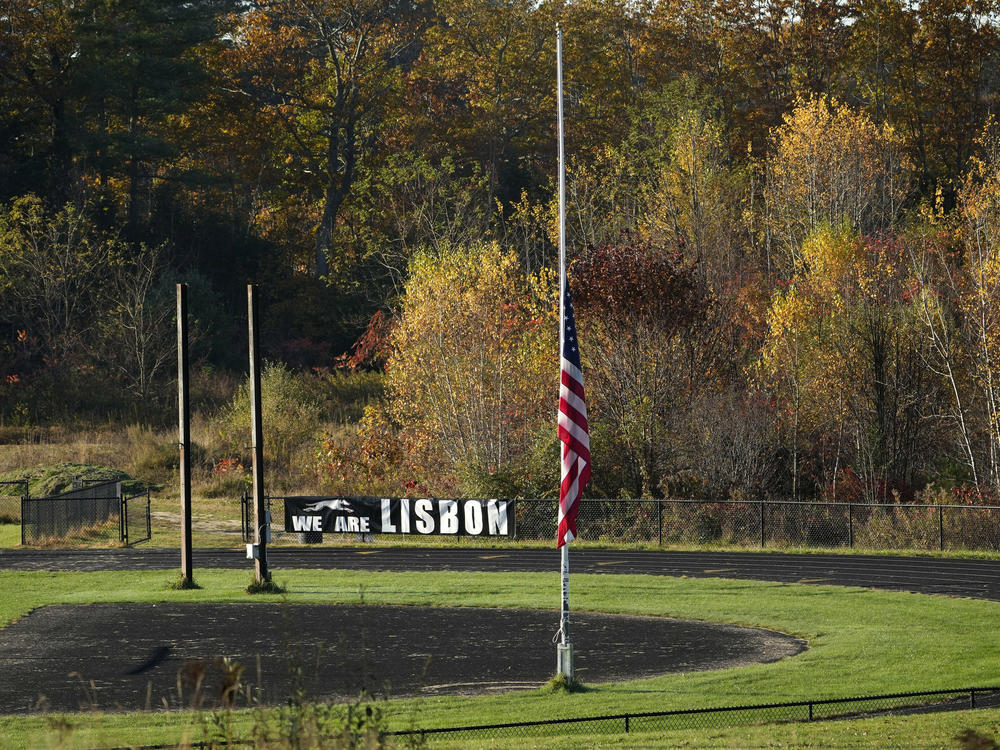 An American flag is set to half mast Saturday on a football field in Lisbon Falls, Maine, just a few hundred yards from a recycling facility where law enforcement found the body of Robert Card, the suspect in this week's mass shootings.