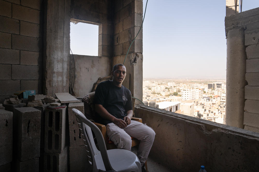 Noor Damaj sits where he was on the night of the Israeli airstrike that hit the mosque next to his home in Jenin.