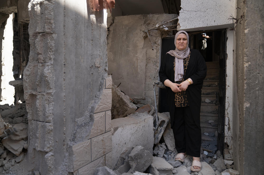 Itaf Damaj stands in the doorway of her home where she and other family members were trapped from the rubble of the strike on the mosque next door, in Jenin.