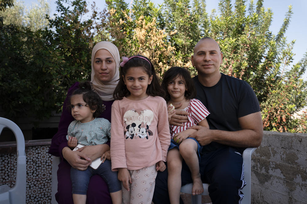Ma'in Zakarneh (right) with his wife, Yasmin, and daughters Salma, 1, Sarah, 5, and Maie, 3, at their home in Jenin.