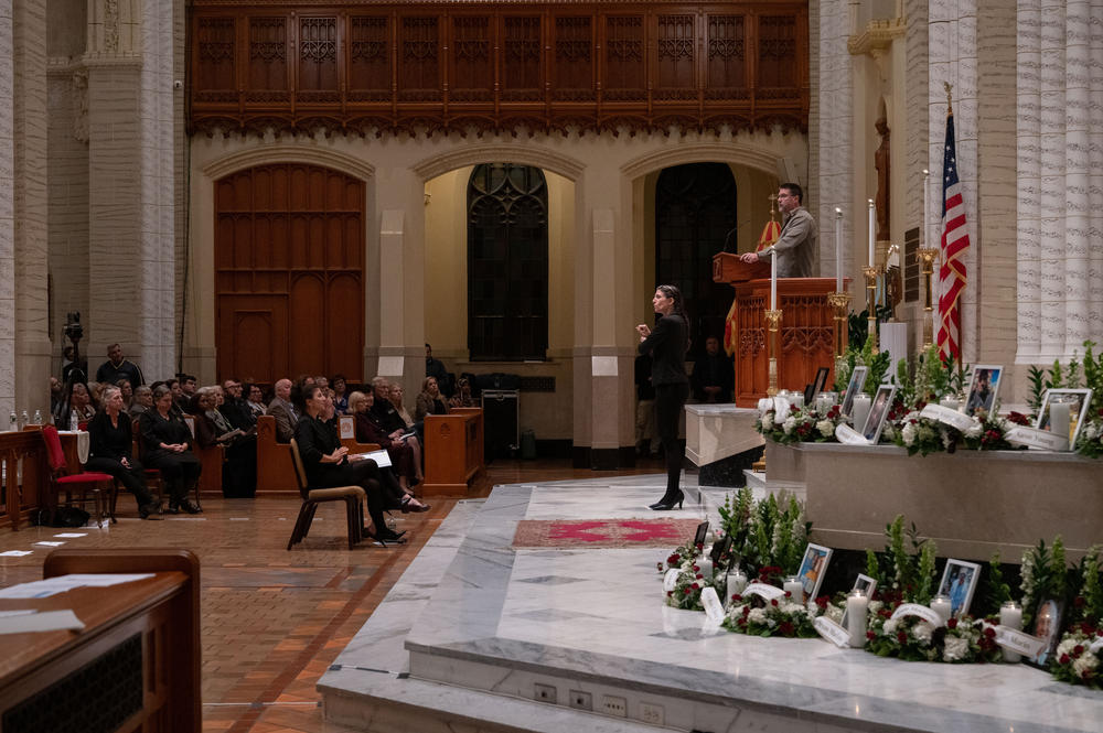 Rev. Allen Austin of Pathway Vineyard Church, right, speaks at the OneLewiston Community Vigil in the Basilica of Saints Peter and Paul in Lewiston, Maine. Regan Thibodeau, second from right, interprets Little's remarks into American Sign Language.