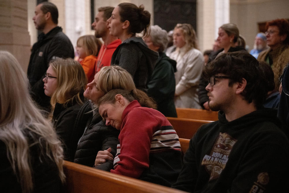 Attendees embrace as others sing along with a closing rendition of <em>Amazing Grace.</em>