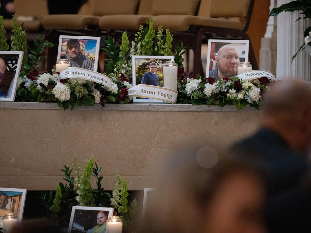 Photos of some of the victims of the Lewiston mass shooting are seen during the vigil.
