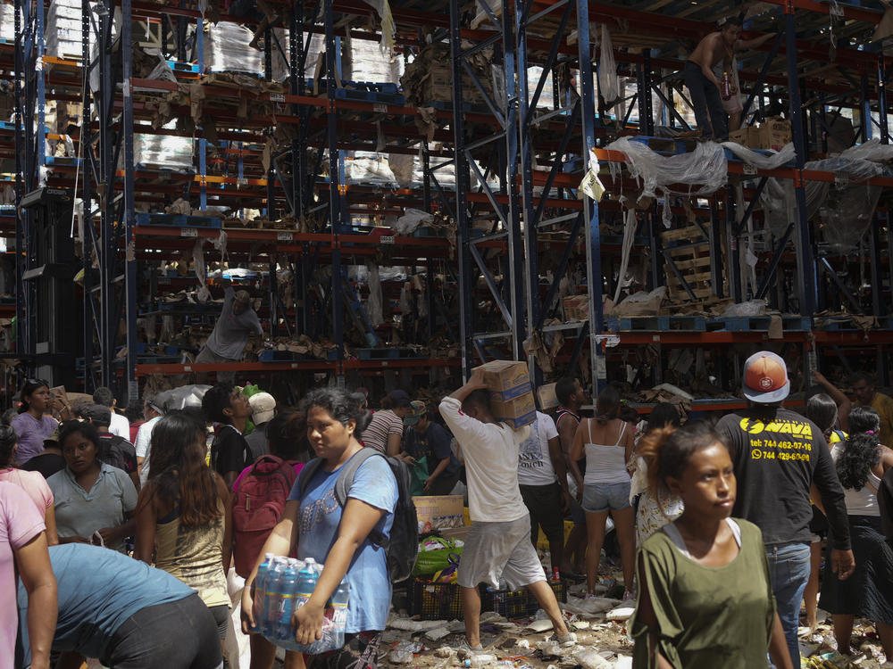 People take items from stores in the aftermath of Hurricane Otis in Acapulco, Mexico, Saturday, Oct. 28, 2023.