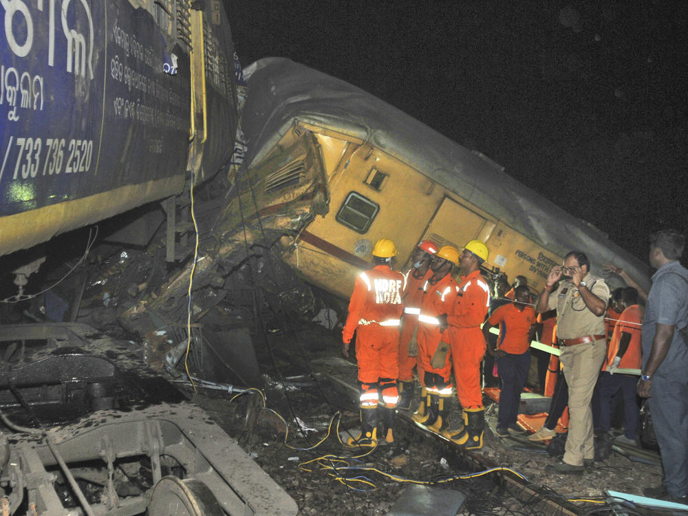 Rescuers and others stand after two passenger trains collided in Vizianagaram district, Andhra Pradesh state, India, Sunday, Oct.29, 2023.