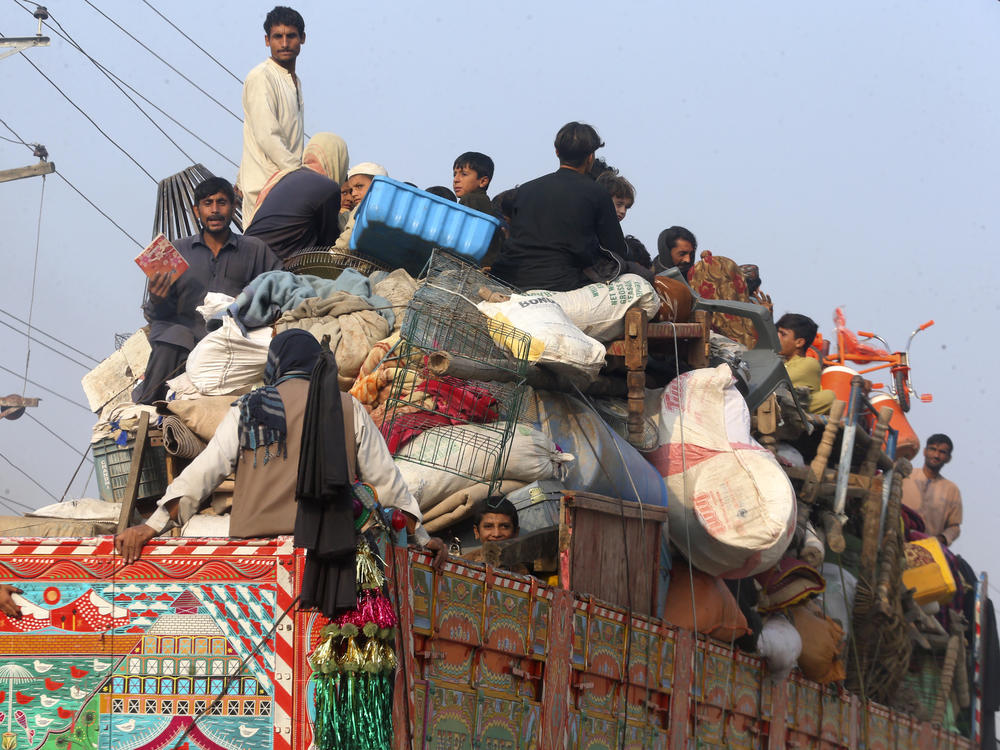 Afghan families ride on a truck heading to a border crossing in Torkham, Pakistan, Tuesday, before the expiration of a Pakistani deadline for those who are in the country illegally to leave or face deportation. Pakistan's crackdown has worried thousands of Afghans in the country awaiting relocation to the United States under a special refugee program since fleeing the Taliban takeover.