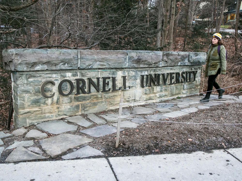 A woman walks by a Cornell University sign on the Ivy League school's campus in Ithaca, New York, on Jan. 14, 2022. Cornell University administrators dispatched campus police to a Jewish center after threatening statements appeared on a discussion board Sunday, Oct. 29, 2023.