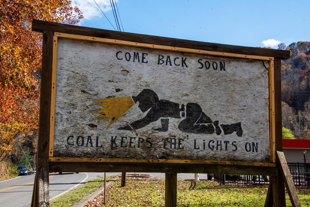 A makeshift billboard depicting a miner working in a 