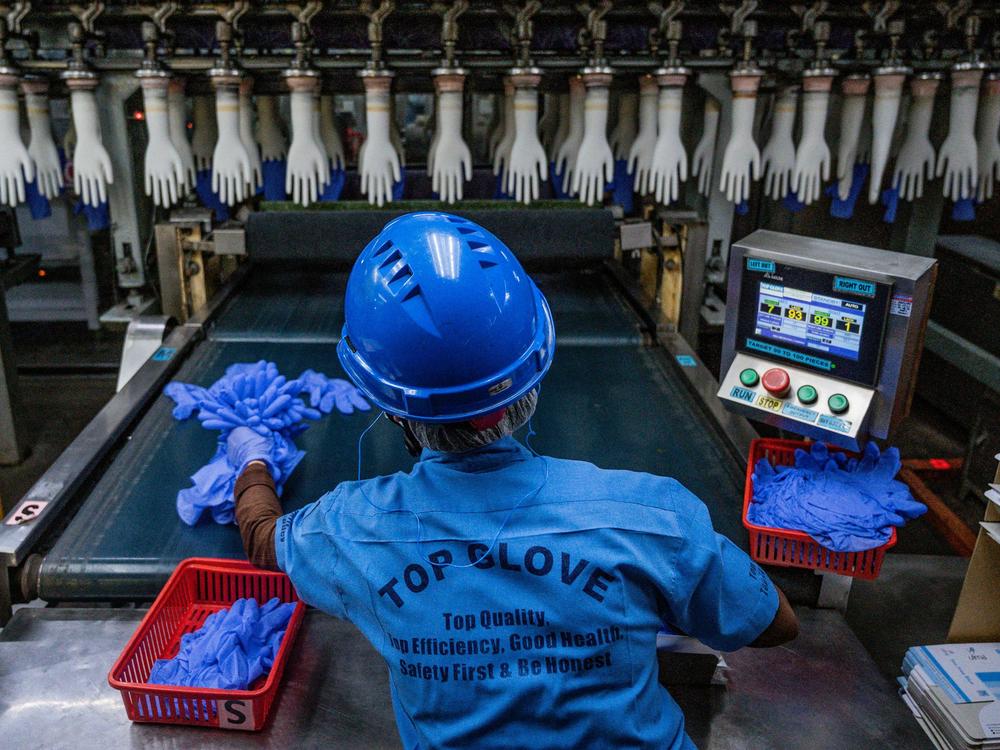 A worker inspects disposable gloves at a factory in Malaysia, a country that has been the top supplier of medical gloves to the U. S. and which is facing increasing competition from China.