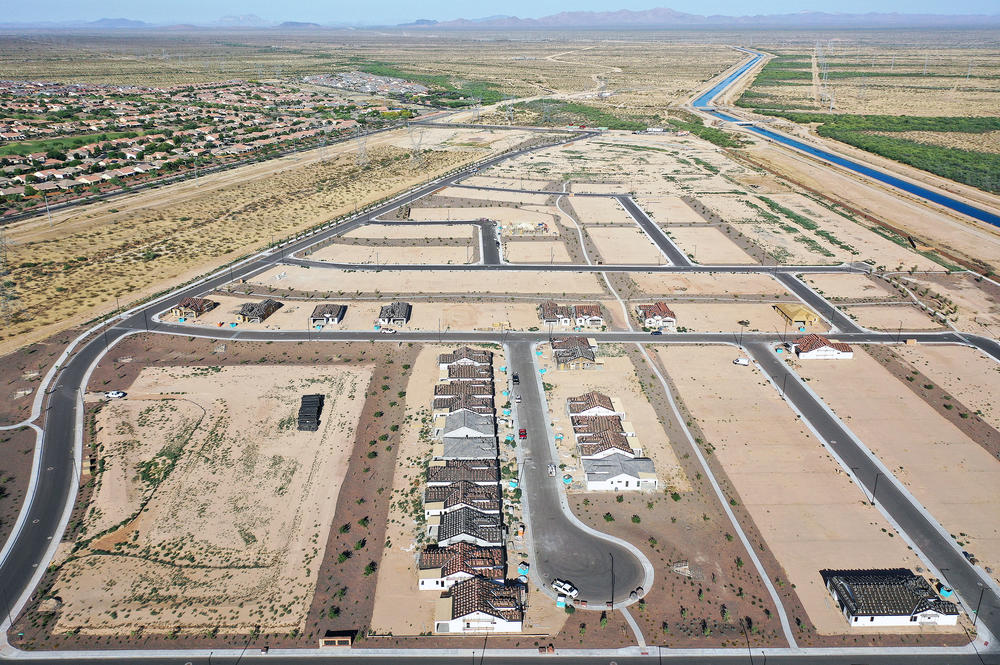 New homes are under construction in June at a housing development near Buckeye, Ariz. A growing number of local governments are considering limits on homebuilding in the face of floods, droughts and wildfires driven by climate change.
