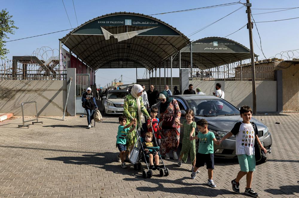 People enter the Rafah border crossing in the southern Gaza Strip before crossing into Egypt.