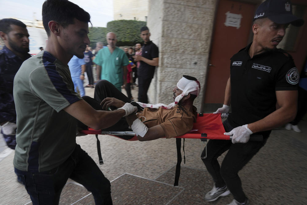 Palestinians wounded in the Israeli bombardment of the Gaza Strip are brought to a treatment room of Al Aqsa Hospital in Deir Al Balah on Tuesday. Basic medical supplies are running short.