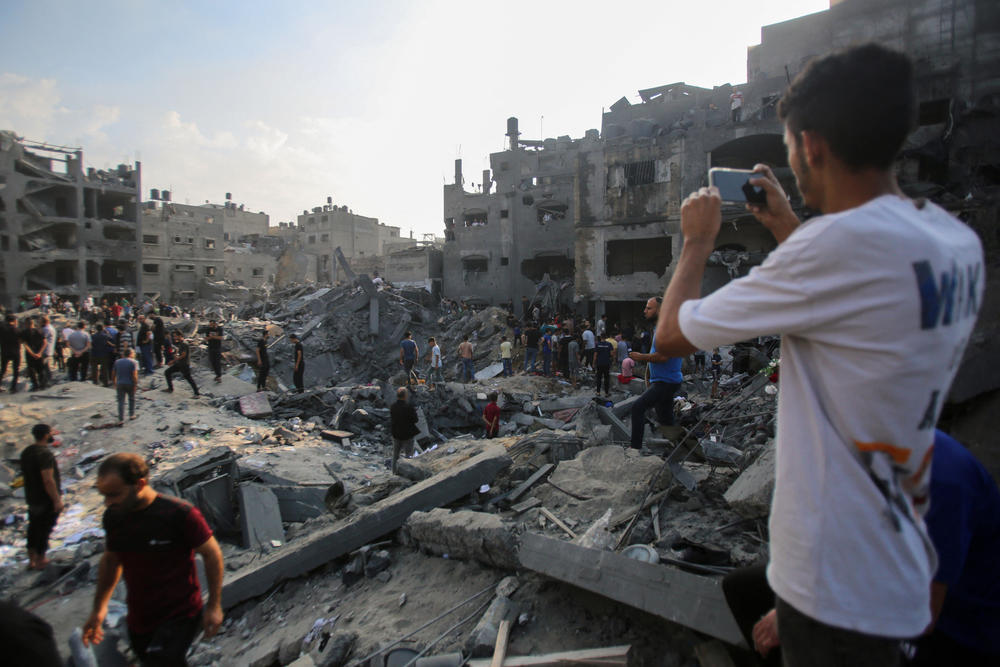 Palestinians check the destruction after an Israeli strike in the Jabalia camp for Palestinian refugees. Palestinians say the strike killed scores of people and Israel says Hamas was operating there.