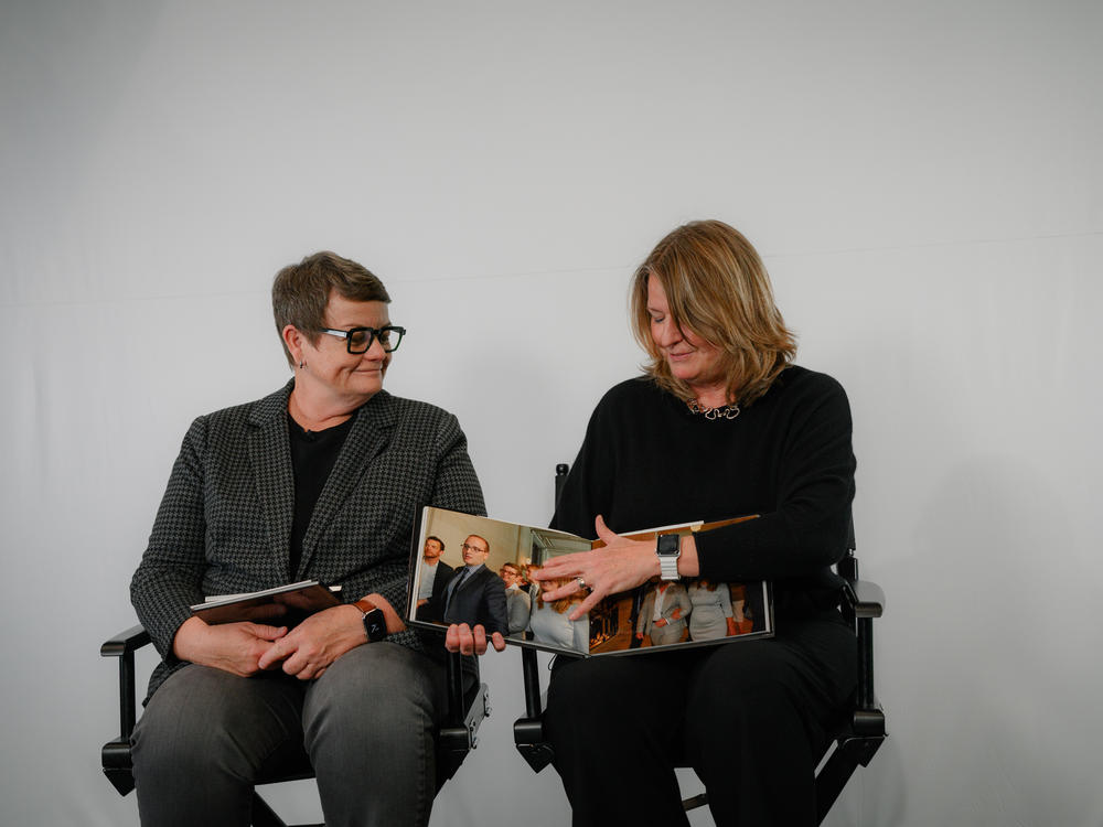 Kris Perry (left) and Sandy Stier, two plaintiffs in the landmark 2010 lawsuit that overturned California's ban on same-sex marriage, share photographs from their wedding ceremony during an interview at the KQED offices in San Francisco on March 3. Stier and Perry came to the studio to watch clips of their testimony in federal court, which KQED had fought to get unsealed, for the first time.