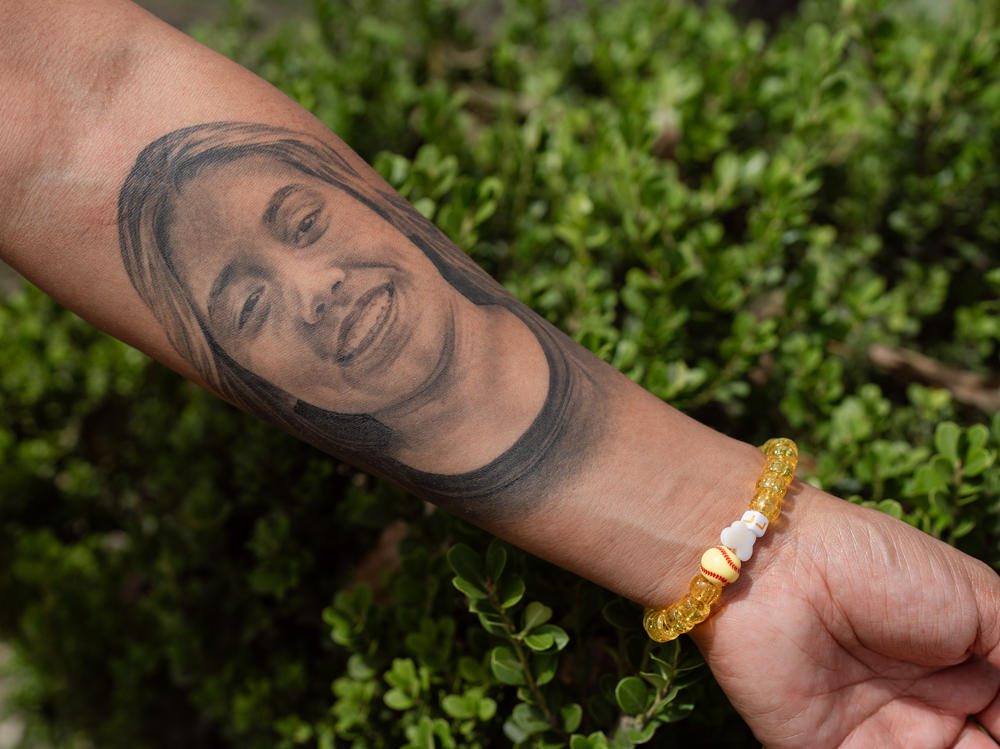 Mata-Rubio shows a tattoo of her daughter Lexi, and a bracelet made in her memory that includes a baseball charm because Lexi played softball.