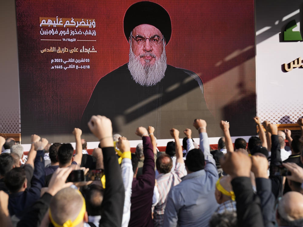 Supporters of the Iranian-backed Hezbollah group raise their fists and cheer as Hezbollah leader Hassan Nasrallah on Friday appears via a video link, during a rally to commemorate Hezbollah fighters who were killed in South Lebanon while fighting against the Israeli forces, in Beirut, Lebanon.