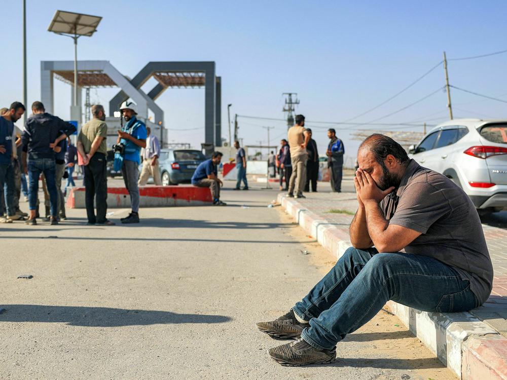 A man reacts as he sits near the gate to the Rafah border crossing with Egypt in the south of the Gaza Strip on November 3, 2023.