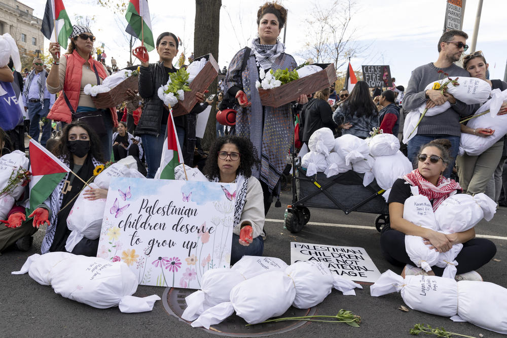 Protesters hold cloth bundles with the names of Palestinian children who were killed by Israeli attacks.
