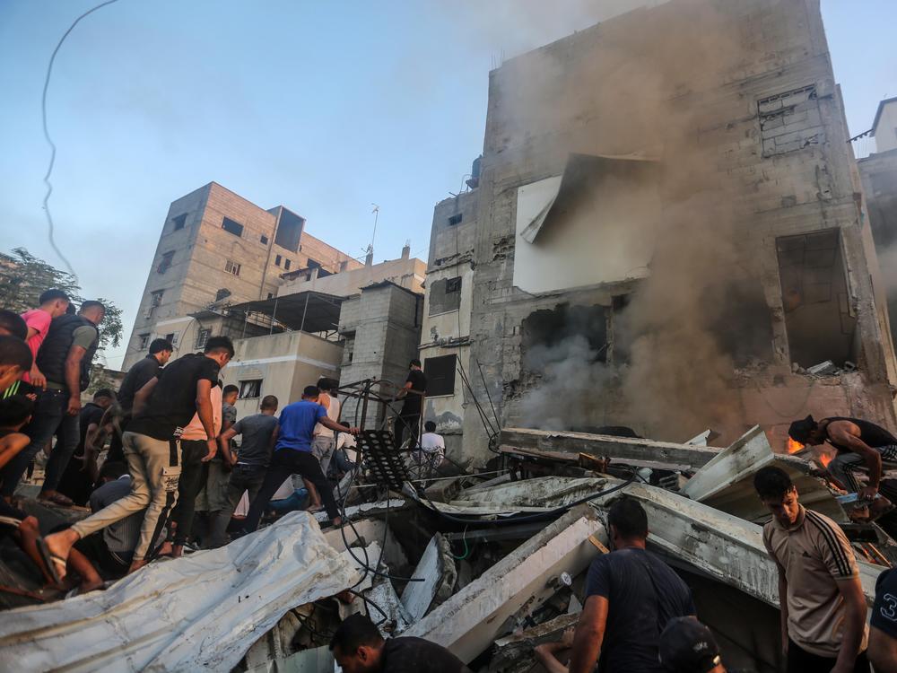 People search through buildings that were destroyed during Israeli air raids in the southern Gaza Strip on Saturday in Khan Younis, Gaza.