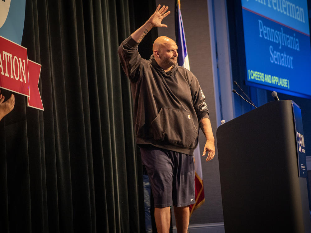 Pennsylvania Sen. John Fetterman walks onto stage in his trademark Carhart hoodie and basketball shorts Saturday night at Prairie Meadows Casino in Altoona, Iowa. Fetterman was the featured speaker at the Iowa Democratic Party's Liberty and Justice Celebration on Nov. 4.
