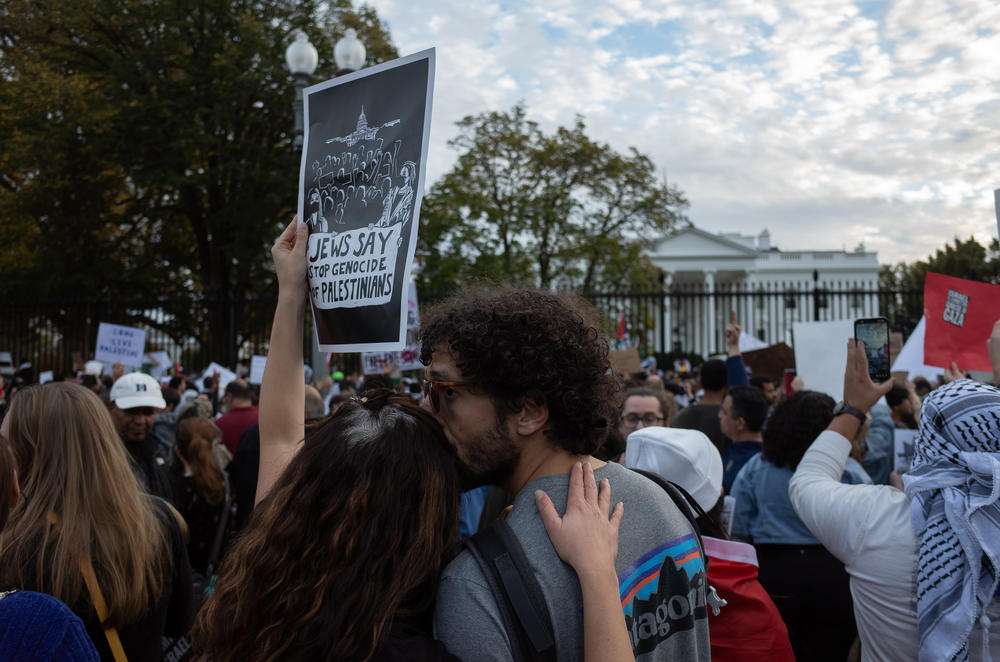 A couple holds a sign that reads 